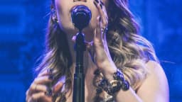 Sandy canta ao microfone durante show