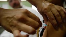 Profissional de saúde aplica vacina contra HPV em paciente sem rosto identificado