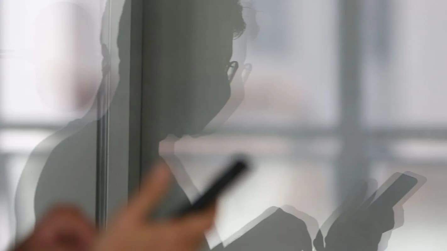 Pessoa segura um celular nas mãos, em foto de contexto sobre consumo de telefonia móvel