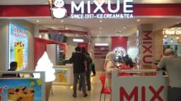 Fachada e interior de uma loja da Mixue com clientes (foto de arquivo, unidade no exterior)