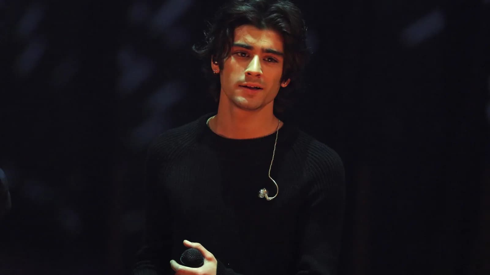Zayn Malik canta ao microfone durante show solo