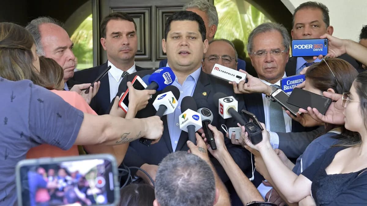 Flávio Bolsonaro cercado por microfones de emissoras de imprensa durante entrevista coletiva