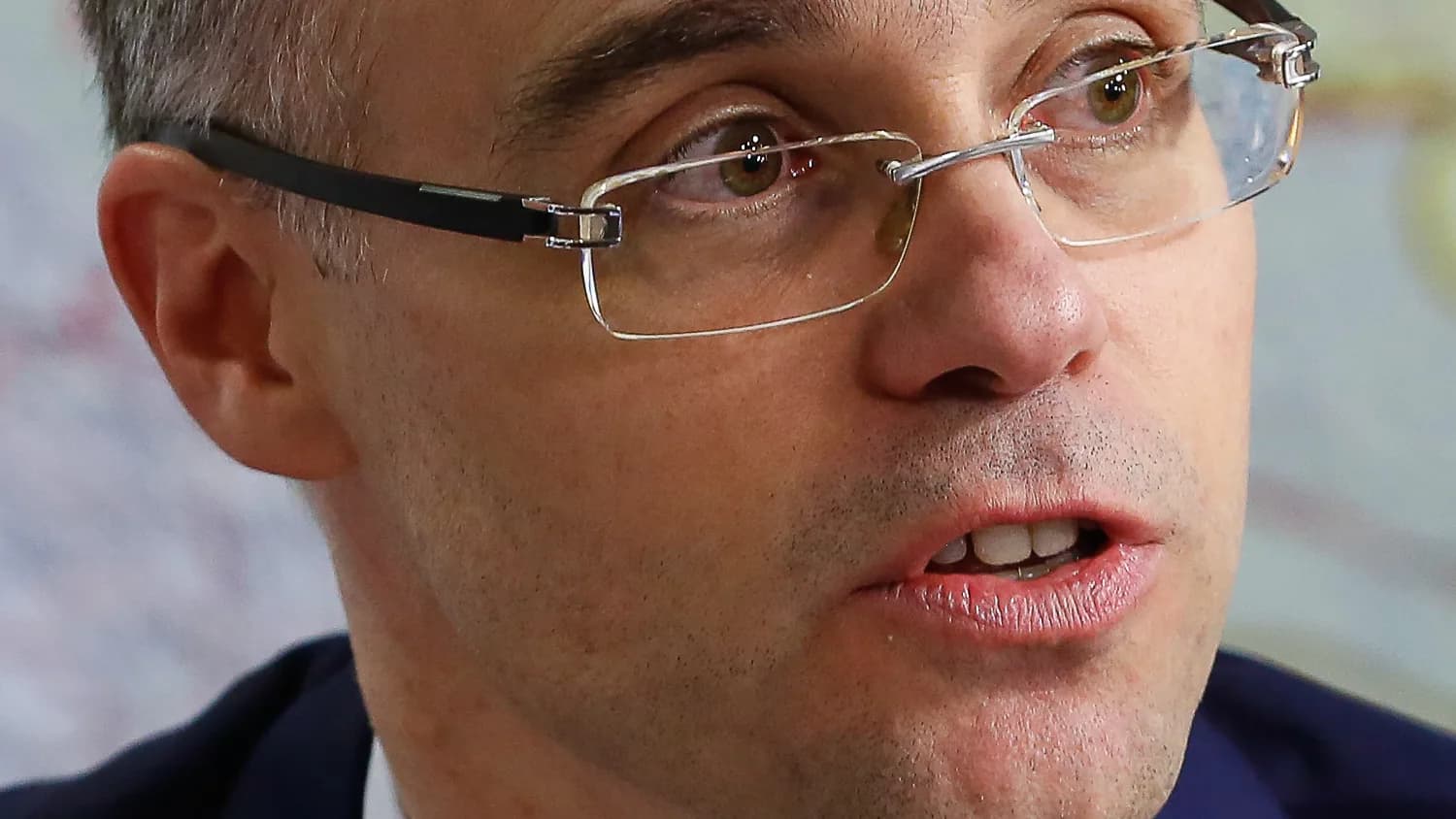 O ministro André Mendonça, do TSE, de óculos e terno, falando ao microfone