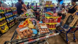 Famílias fazem compras com carrinhos cheios em supermercado popular