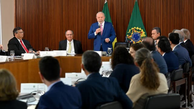 Lula discursa em reunião ministerial, com bandeiras do Brasil ao fundo