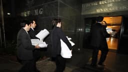 Servidores entram no prédio do Tribunal Regional Eleitoral de Minas Gerais carregando processos