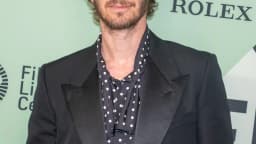 Andrew Garfield em evento de divulgação de filme, usando terno escuro