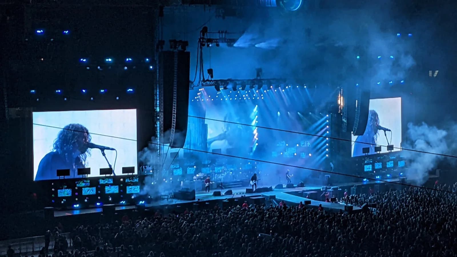 Foo Fighters se apresenta em palco com telões e multidão durante show noturno