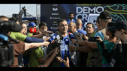 Ministro Kássio Nunes Marques, presidente do TSE, cercado de microfones ao falar com jornalistas em evento público