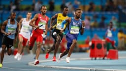 Atletas disputam corrida de velocidade em pista de atletismo, imagem de arquivo
