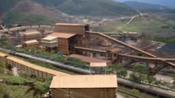 Complexo industrial de mineração de minério de ferro da Vale, com esteiras, vagões e pátio de estocagem entre montanhas, em Minas Gerais