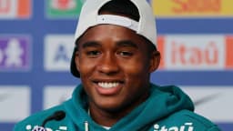 Endrick sorri durante entrevista com uniforme da seleção brasileira