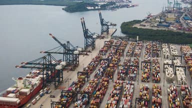 Vista aérea do Porto de Santos com navio cargueiro atracado, guindastes e pátio de contêineres