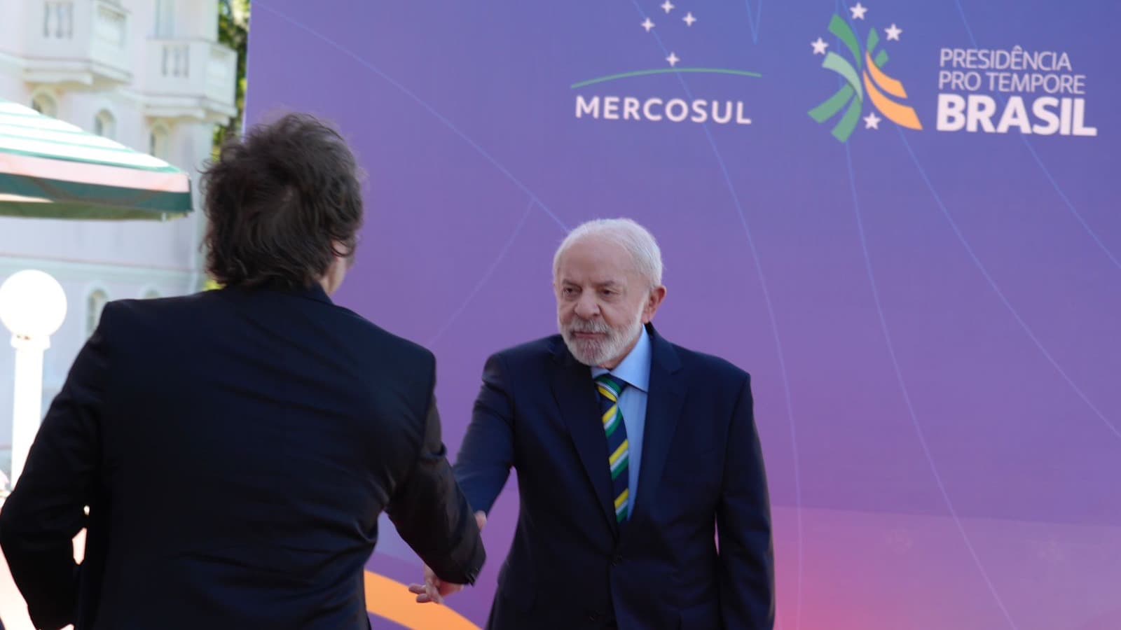 Lula aperta a mão de Javier Milei diante de painel do Mercosul em dezembro de 2025; imagem de arquivo