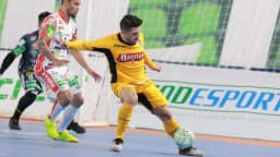 Jogador do Sorocaba, de amarelo e preto, disputa bola em partida de futsal