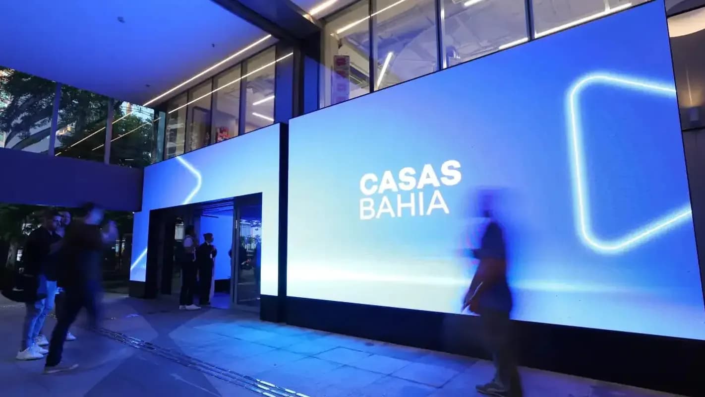 Interior de loja da Casas Bahia iluminado, com clientes circulando entre os corredores