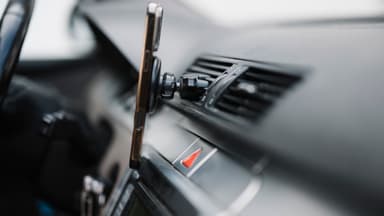 Smartphone preso ao suporte do painel de um carro, imagem ilustrativa do uso do celular durante corridas de aplicativo