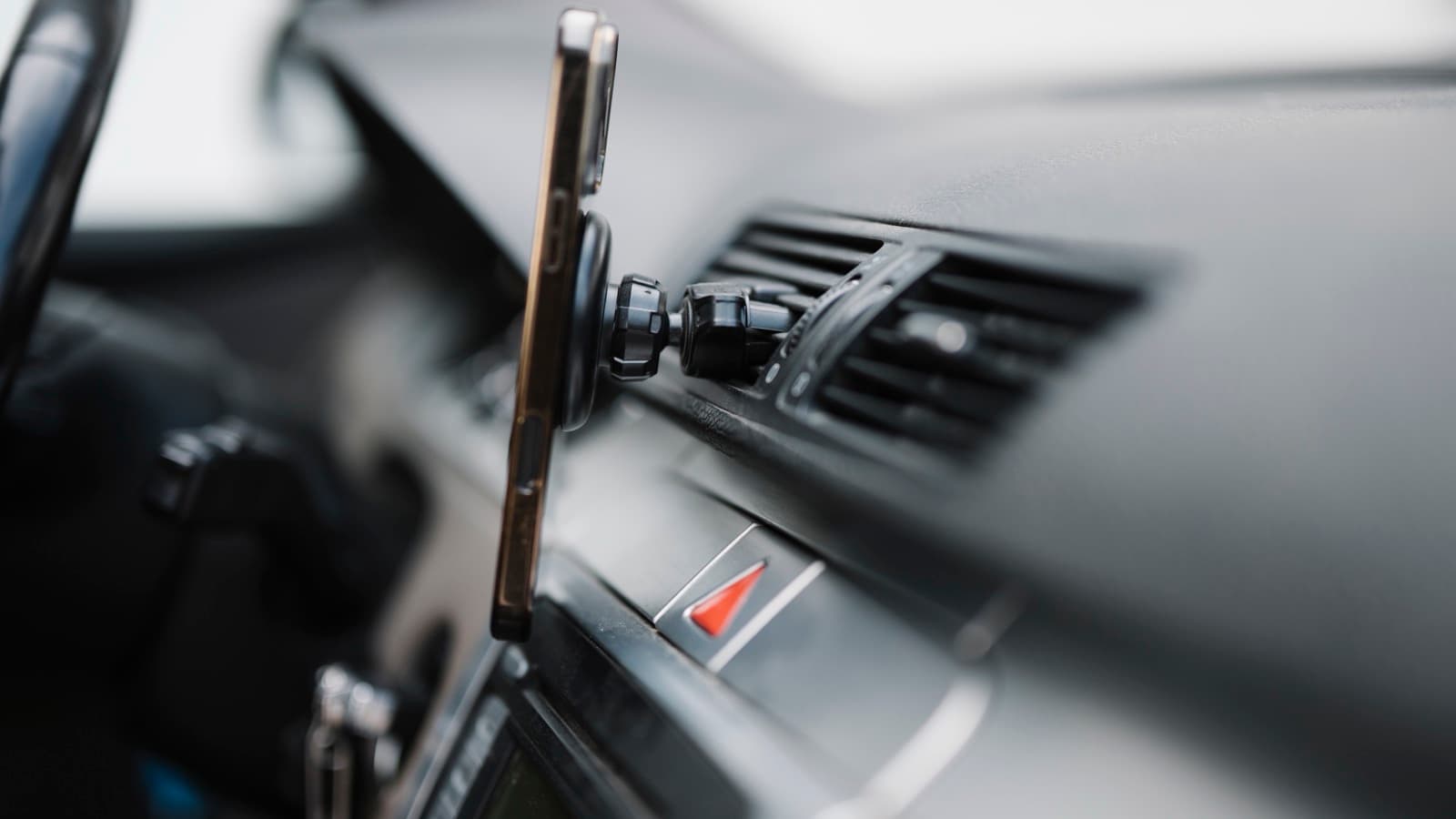 Smartphone preso ao suporte do painel de um carro, imagem ilustrativa do uso do celular durante corridas de aplicativo