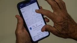 Homem consulta local de votação em aplicativo de celular