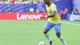 Jogador da seleção brasileira conduz a bola durante partida
