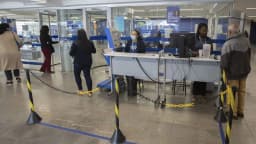 Pessoas aguardam atendimento para renegociar dívidas em agência de atendimento ao consumidor