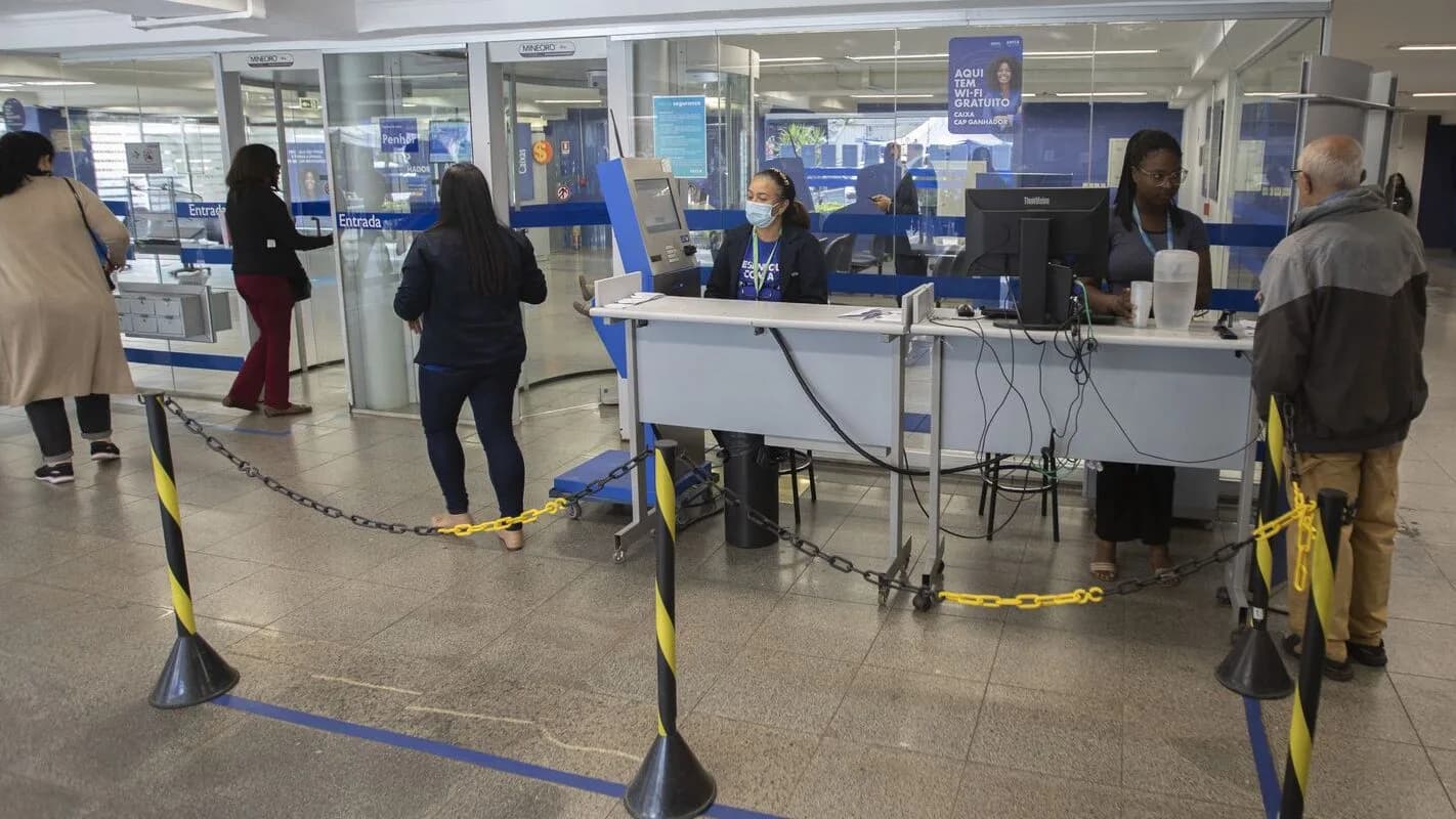 Pessoas aguardam atendimento para renegociar dívidas em agência de atendimento ao consumidor