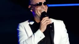 Pitbull se apresenta em show, de terno branco e óculos escuros (foto de arquivo)