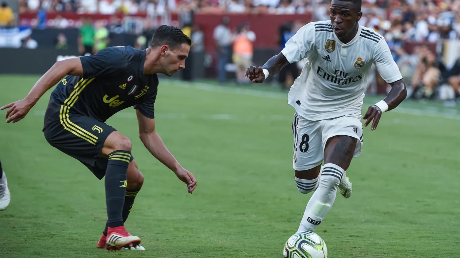 Vinicius Júnior em campo com o uniforme branco do Real Madrid