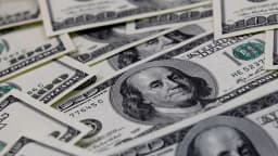 Cédulas de dólar sendo contadas à mão, foto de arquivo