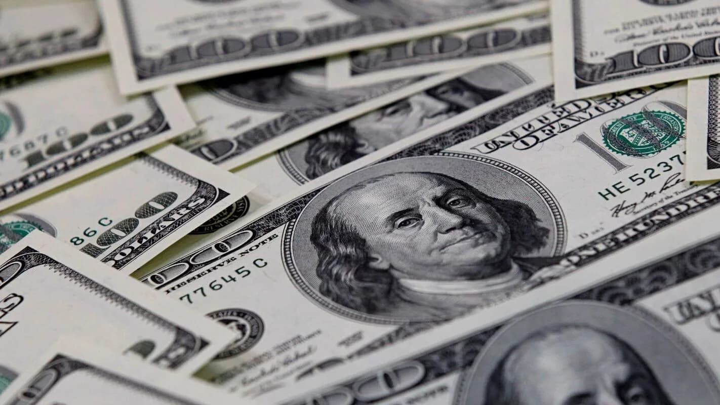 Cédulas de dólar sendo contadas à mão, foto de arquivo