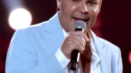 Eduardo Costa canta ao microfone em palco durante show