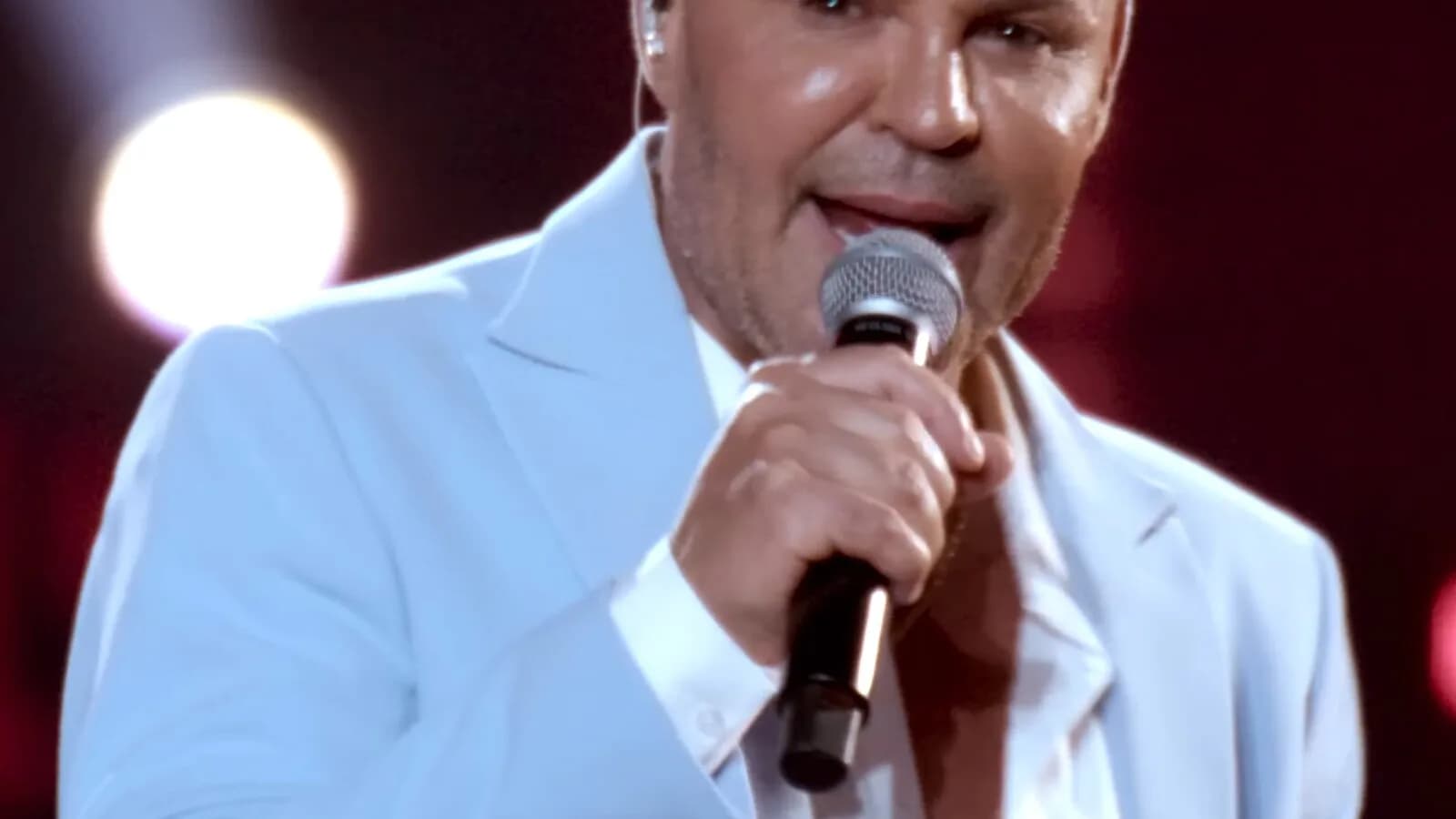 Eduardo Costa canta ao microfone em palco durante show