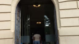 Fachada histórica de prédio no Centro de Belo Horizonte, com visitante na entrada