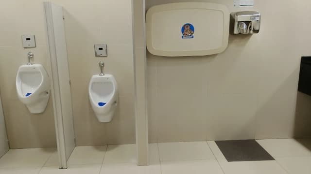 Mictórios em banheiro masculino de shopping, com divisórias entre eles