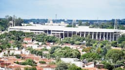 Vista aérea do Estádio Municipal Fonte Luminosa, em Araraquara, cercado por árvores e casas