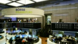 Pregão da Bolsa de Frankfurt, com operadores trabalhando em telas sob o painel com o nome Börse Frankfurt