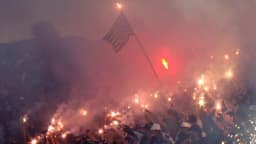 Torcida do Corinthians com tochas e bandeiras em evento no entorno do estádio
