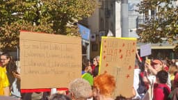 Manifestantes seguram cartazes em ato de apoio a Lula em Lisboa