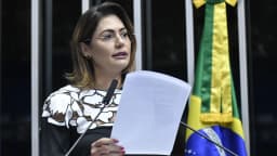 Michelle Bolsonaro discursa em púlpito do Senado com bandeira do Brasil ao fundo