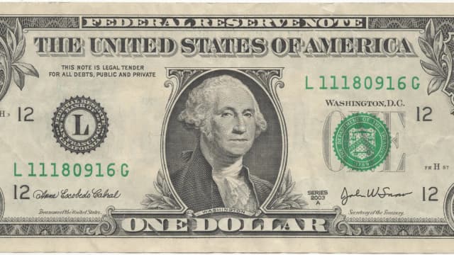 Cédula de um dólar americano, símbolo da moeda que domina o comércio internacional