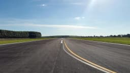 Pista de aeroporto vazia sob céu azul, ilustrando o setor de navegação aérea
