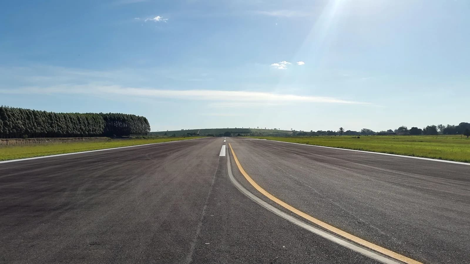 Pista de aeroporto vazia sob céu azul, ilustrando o setor de navegação aérea