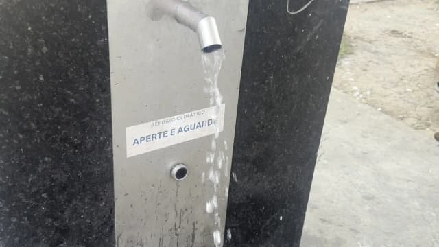 Água sai da bica do bebedouro do refúgio climático da Avenida Olegário Maciel, no Centro de Belo Horizonte, acima da placa "Aperte e aguarde"