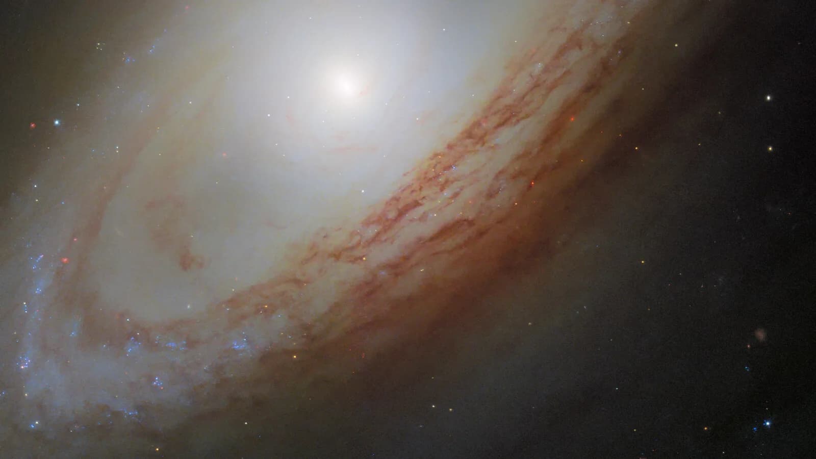 Imagem do Telescópio Hubble mostra a galáxia espiral NGC 4698, com bojo brilhante e faixas de poeira