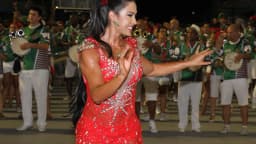 Gracyanne Barbosa dança durante desfile, vestida de vermelho