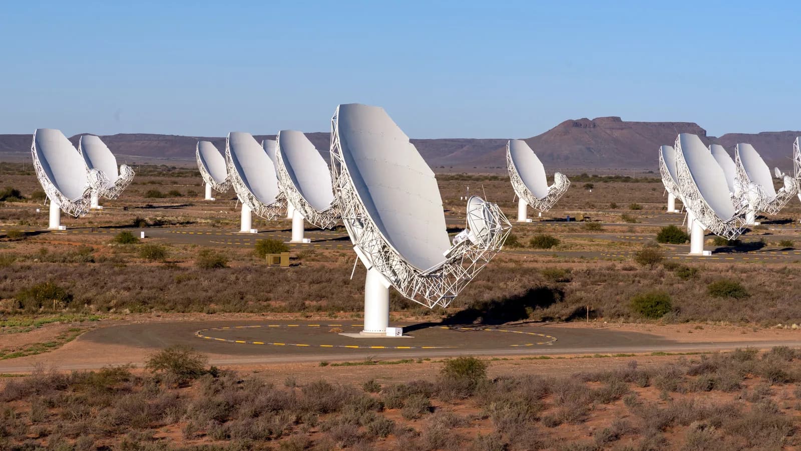 Conjunto de antenas parabólicas brancas do radiotelescópio MeerKAT, no deserto do Karoo, África do Sul