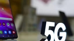 Smartphone exibido ao lado de totem com a marca 5G