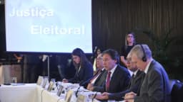 Painel sobre Justiça Eleitoral com autoridades sentadas à mesa, em evento de arquivo
