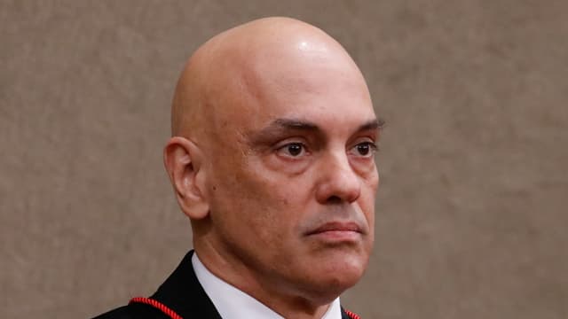 Foto de arquivo do ministro Alexandre de Moraes, de toga preta com detalhes em vermelho, durante cerimônia em Brasília em 2022