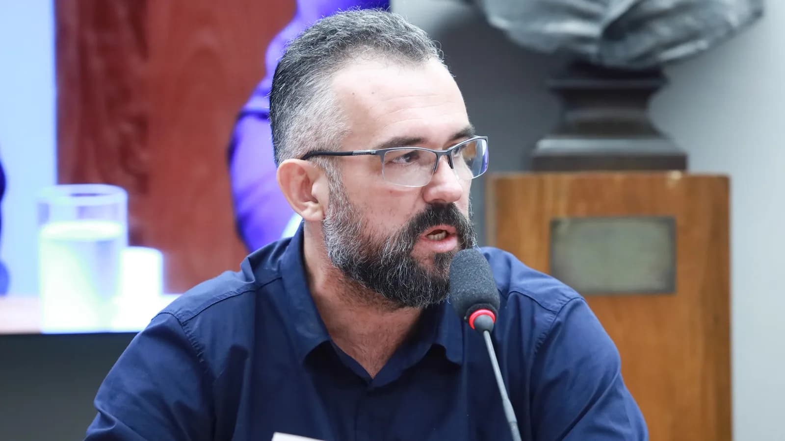 Cafeicultor de barba e óculos fala ao microfone durante audiência pública sobre o setor cafeeiro (foto de arquivo, dezembro de 2023)